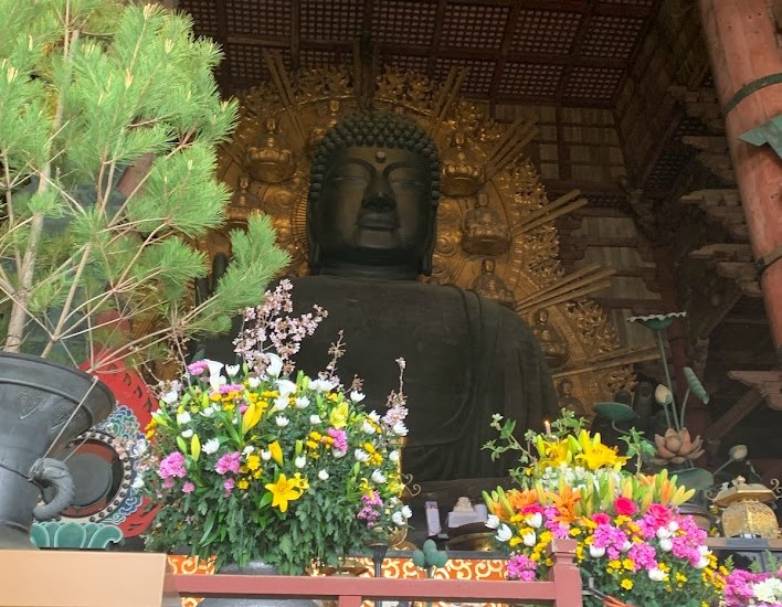 大仏様のお顔と花と松の写真