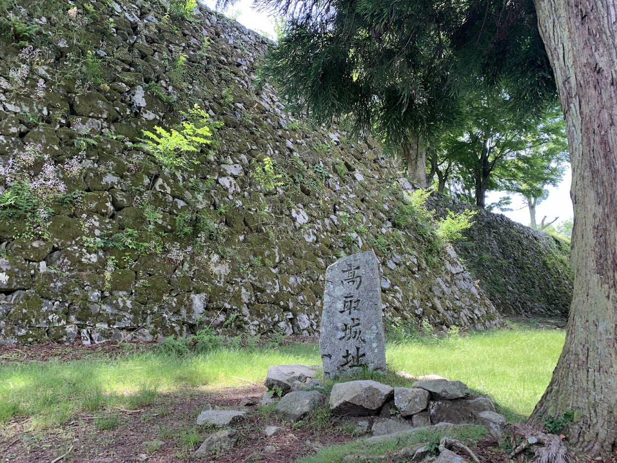 高取城の石崖と木と石碑の写真