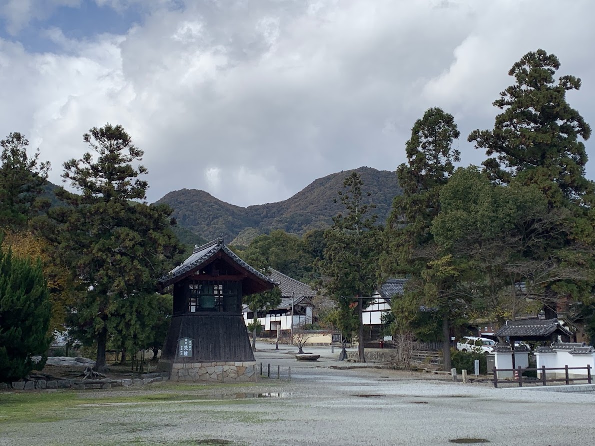 當麻寺の鐘楼と二上山と松の写真 Photo of the bell tower, Mount Nijo, and pine tree at Taima-dera Temple