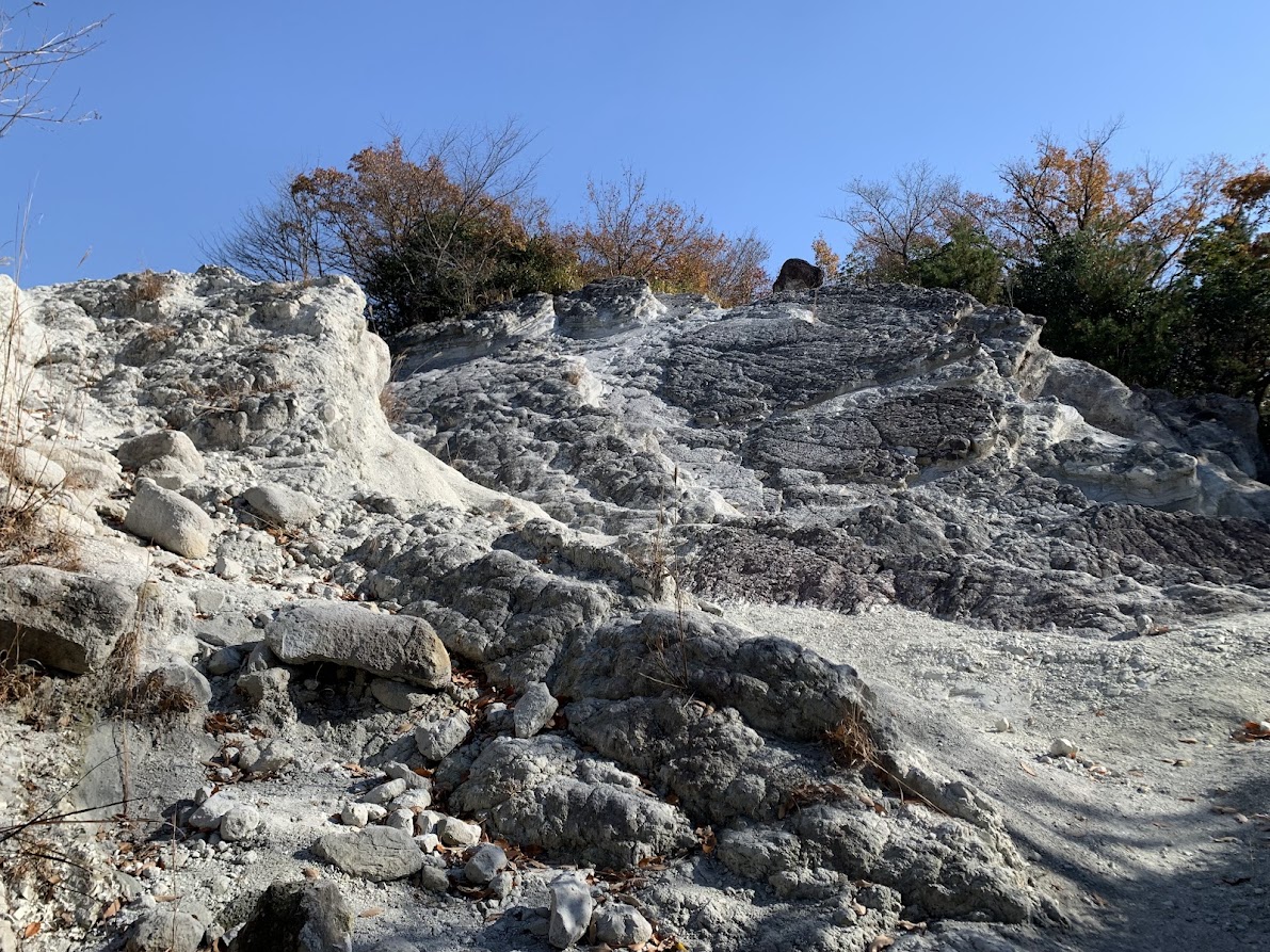 屯鶴峯の凝灰岩の斜面と青空の写真 Photo of the tuff slope and blue sky at Donzurubō