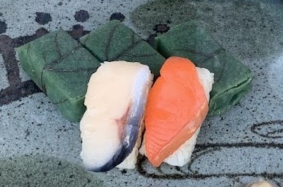 柿の葉寿しと緑の皿の写真 Photo of kaki no ha sushi and a green plate